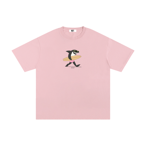 Pink t-shirt with a shark holding a surfboard graphic on a white background